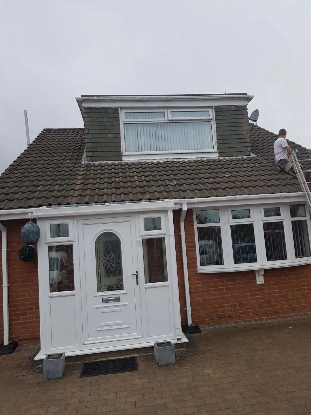 Chalet bungalow with moss-covered concrete tiles and a tile-hung front dormer before work