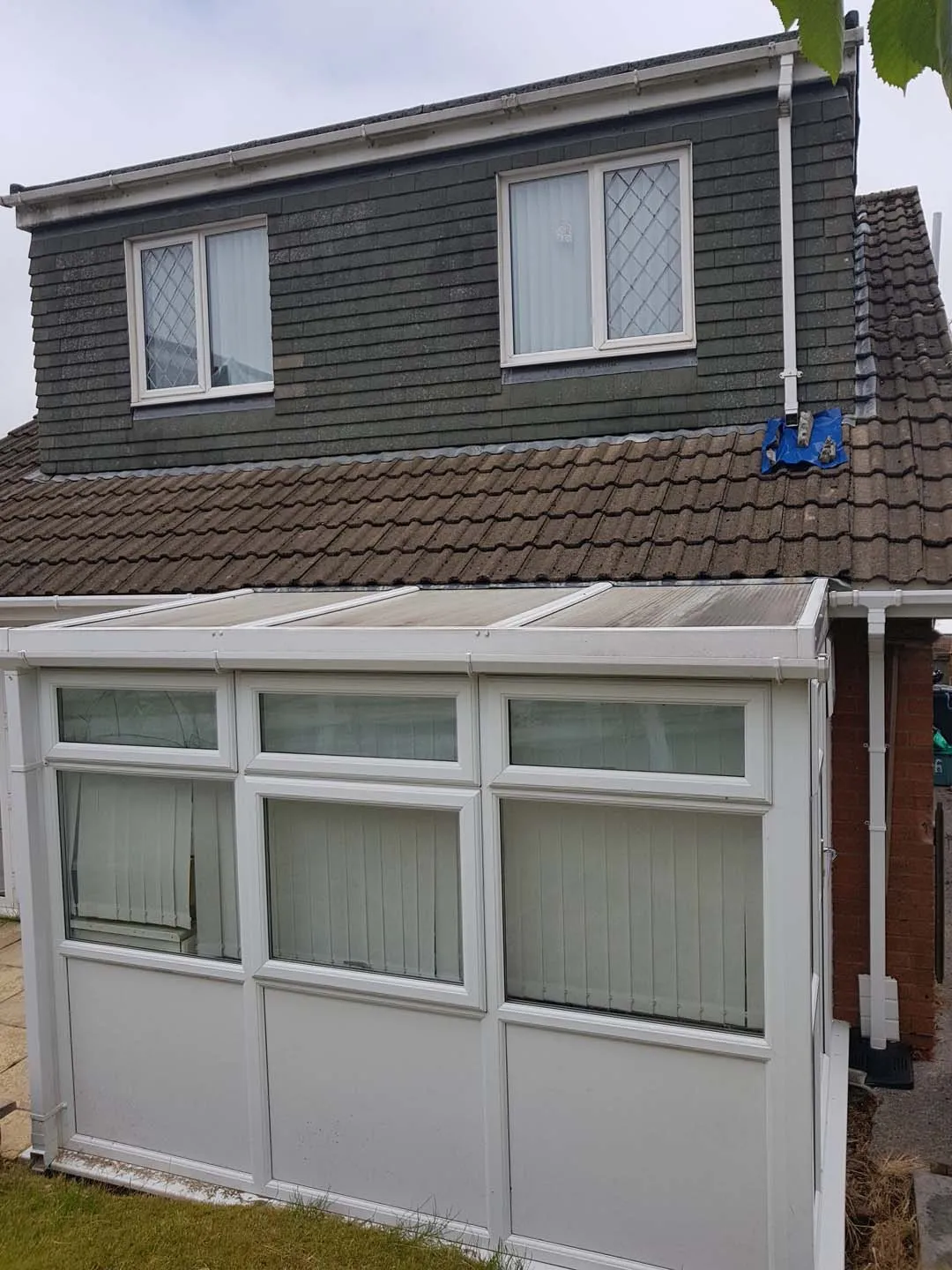 Rear double-window dormer with old tile hanging above a conservatory roof