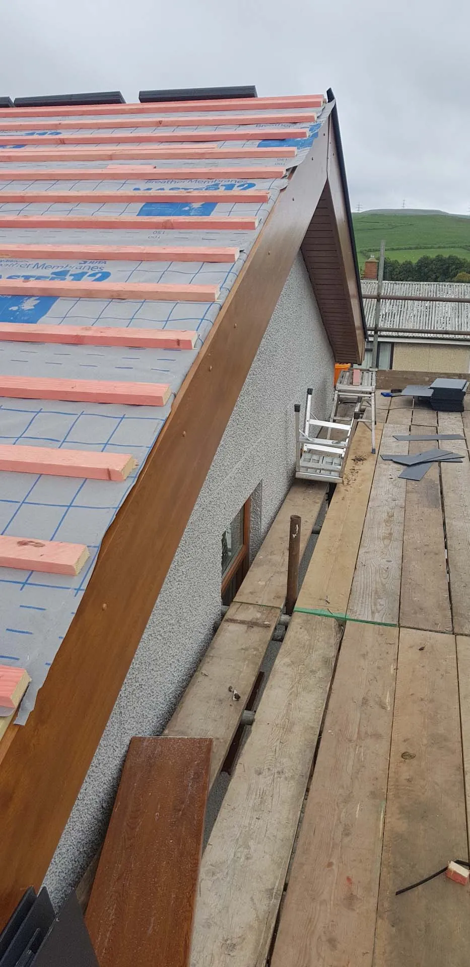 Gable with new woodgrain bargeboard, breathable membrane and treated battens ready for tiles