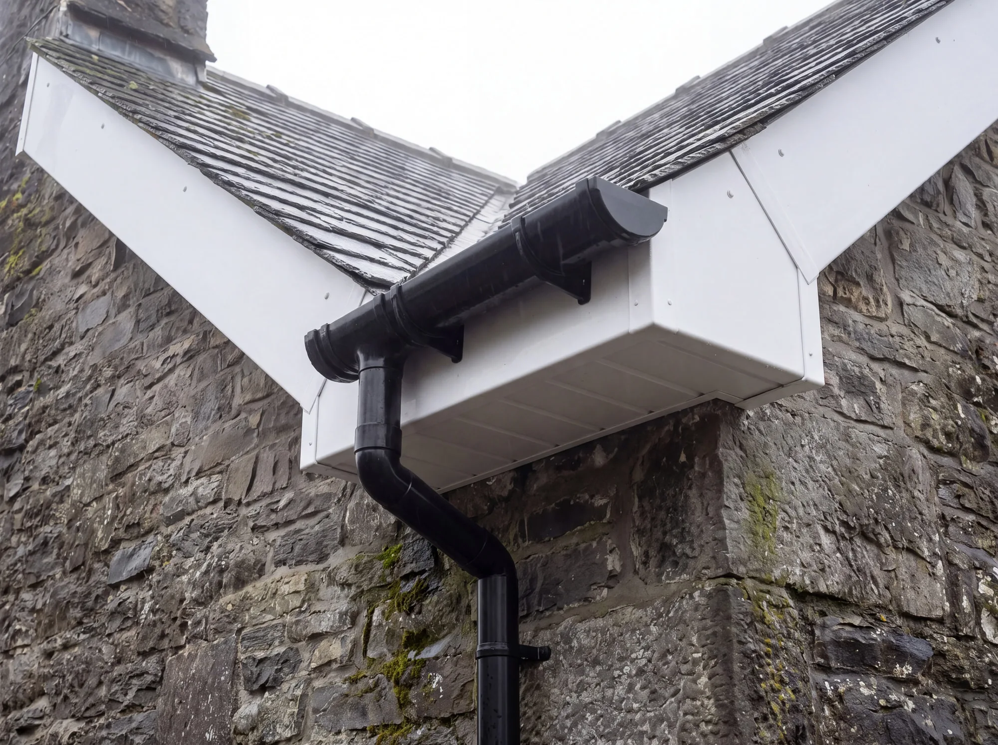 Newly fitted fascia, soffit and half-round guttering at the eaves of a house